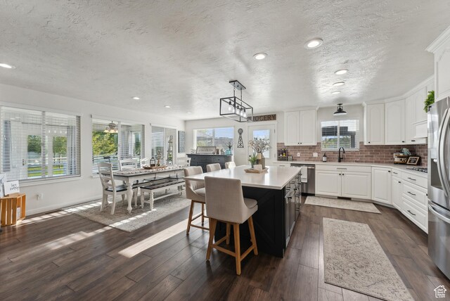 kitchen featuring a textured ceiling, a kitchen island, appliances with stainless steel finishes, and light countertops