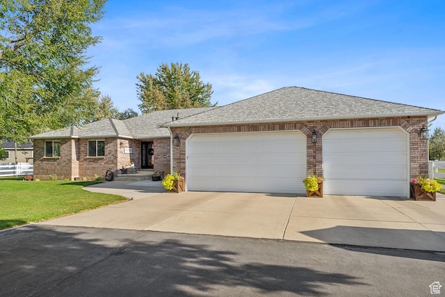 ranch-style home with concrete driveway, a shingled roof, brick siding, a front lawn, and a garage