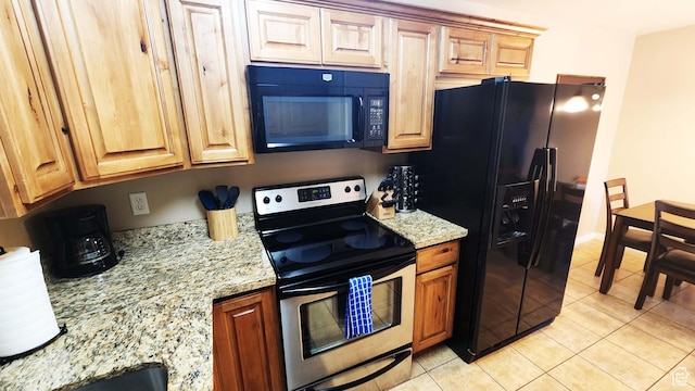 2511 Redcliff Rd Unit 1-E, Moab, UT 84532 - kitchen featuring light stone counters, light tile patterned floors, and black appliances