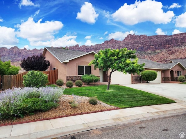 3448 Tierra Del Sol Dr, Moab, UT 84532 - ranch-style house featuring stucco siding, a mountain view, driveway, a garage, and fence