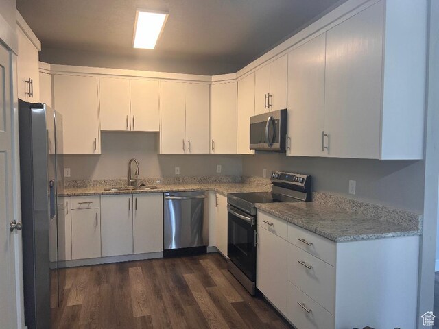 6932 N 2750 W, Honeyville, UT 84314 - kitchen with white cabinets, a sink, dark wood-style flooring, light stone countertops, and appliances with stainless steel finishes