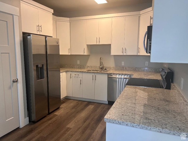 6932 N 2750 W, Honeyville, UT 84314 - kitchen featuring white cabinets, dark wood finished floors, light stone counters, a sink, and appliances with stainless steel finishes