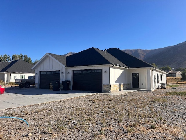 6932 N 2750 W, Honeyville, UT 84314 - exterior space featuring driveway, board and batten siding, a mountain view, and a garage