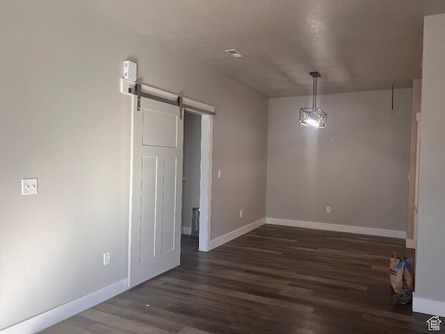 6932 N 2750 W, Honeyville, UT 84314 - unfurnished dining area featuring baseboards, dark wood-style floors, and a barn door