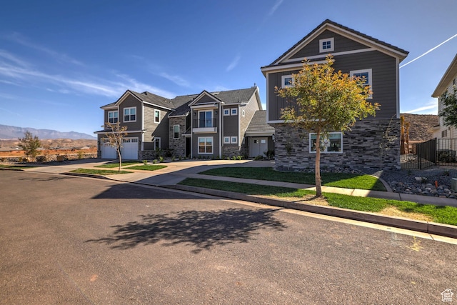 4971 S Cattail Way, Washington, UT 84780 - view of front of home featuring a mountain view, driveway, stone siding, and a garage