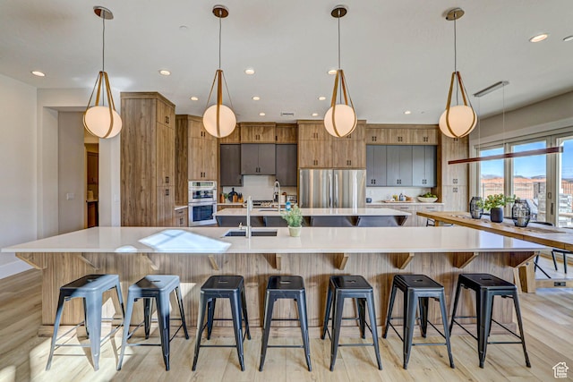 4971 S Cattail Way, Washington, UT 84780 - kitchen featuring a large island, appliances with stainless steel finishes, and light wood-type flooring