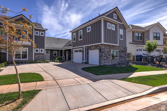 4971 S Cattail Way, Washington, UT 84780 - view of front of home with board and batten siding, stone siding, a garage, and driveway