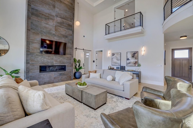 4971 S Cattail Way, Washington, UT 84780 - living room featuring a towering ceiling, visible vents, wood finished floors, a tiled fireplace, and baseboards
