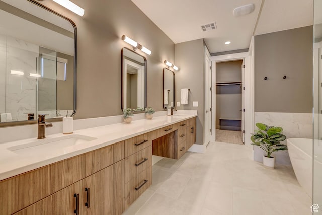 4971 S Cattail Way, Washington, UT 84780 - full bath with visible vents, a freestanding tub, a sink, double vanity, and a walk in closet