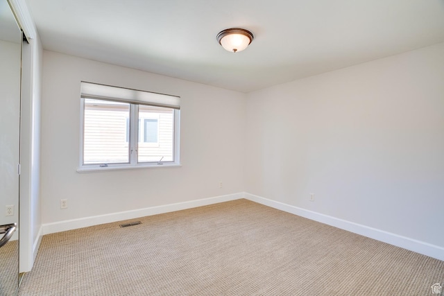 spare room with visible vents, carpet flooring, and baseboards