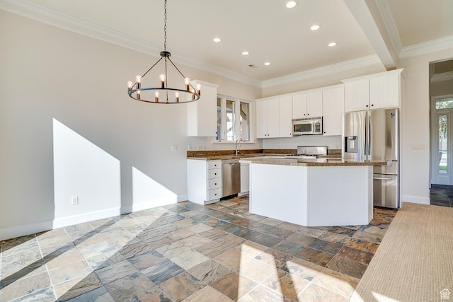 kitchen with crown molding, a sink, baseboards, appliances with stainless steel finishes, and a kitchen island