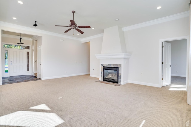 unfurnished living room with ceiling fan, carpet, baseboards, and ornamental molding