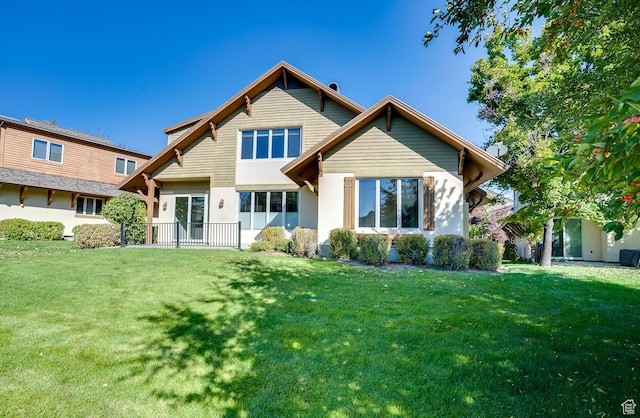 back of property with a yard and stucco siding