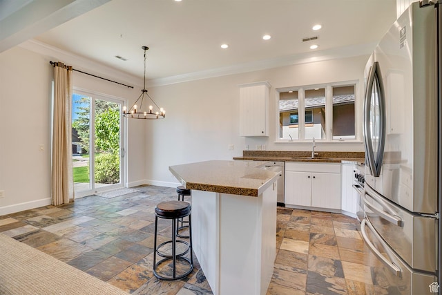 49 W Oberland Ct, Midway, UT 84049 - kitchen featuring stainless steel appliances, stone tile floors, a sink, baseboards, and ornamental molding