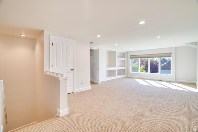 unfurnished room with recessed lighting, built in features, baseboards, and light carpet