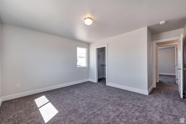 1777 S 3725th St W Unit 107, Taylor, UT 84401 - unfurnished bedroom with dark colored carpet, baseboards, and a spacious closet