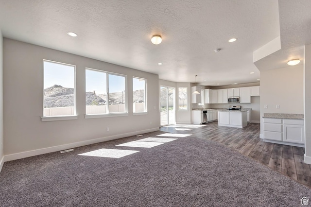 1777 S 3725th St W Unit 107, Taylor, UT 84401 - unfurnished living room featuring baseboards, recessed lighting, dark carpet, a textured ceiling, and dark wood-style flooring