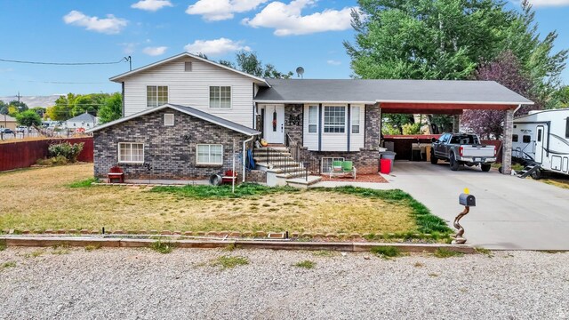 245 N 700 E, Richfield, UT 84701 - tri-level home with a front yard, fence, brick siding, driveway, and an attached carport