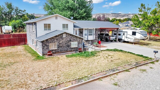 245 N 700 E, Richfield, UT 84701 - split level home with concrete driveway, fence, an attached carport, and a front lawn