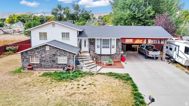 245 N 700 E, Richfield, UT 84701 - split level home with an attached carport, a shingled roof, a front yard, a mountain view, and concrete driveway