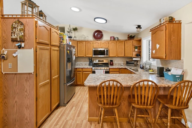 245 N 700 E, Richfield, UT 84701 - kitchen with backsplash, light wood-style flooring, a peninsula, and stainless steel appliances