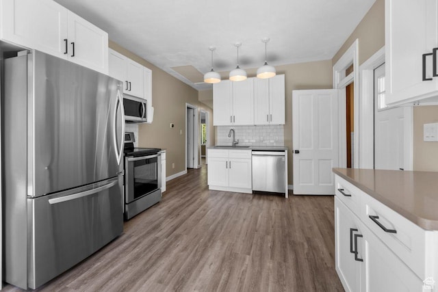 327 E Coatsville Ave S, Salt Lake City, UT 84115 - kitchen featuring stainless steel appliances, backsplash, wood finished floors, and white cabinetry