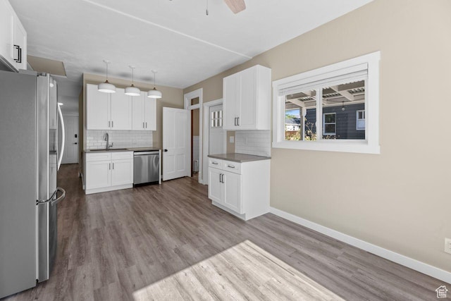 327 E Coatsville Ave S, Salt Lake City, UT 84115 - kitchen with appliances with stainless steel finishes, decorative backsplash, and white cabinets