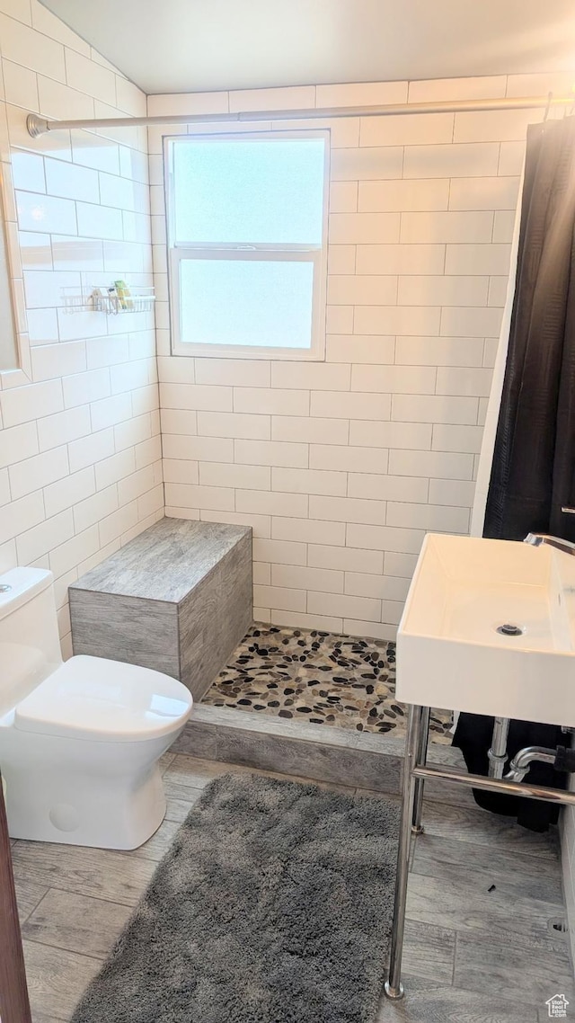 327 E Coatsville Ave S, Salt Lake City, UT 84115 - bathroom featuring a stall shower, toilet, wood finished floors, and tile walls