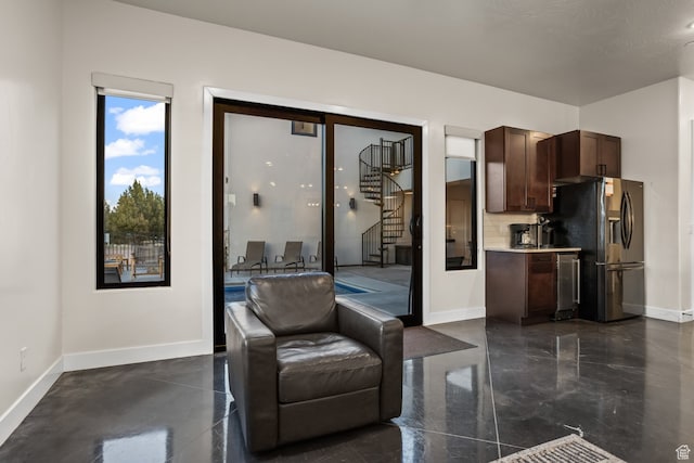 living room featuring baseboards and stairs
