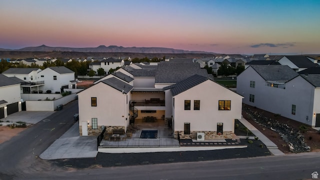 aerial view at dusk featuring a mountain view and a residential view