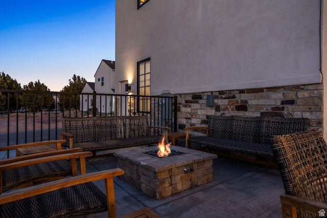 patio terrace at dusk featuring a fire pit