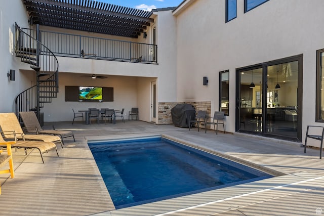 outdoor pool featuring outdoor dining space, a patio area, stairway, and grilling area