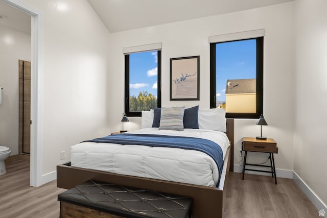 bedroom with visible vents, baseboards, and wood finished floors