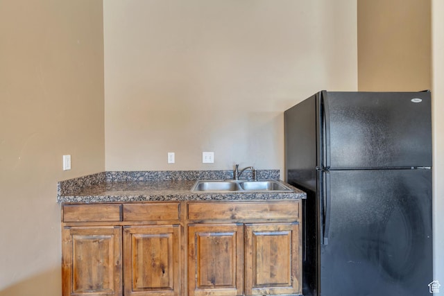 376 S 740 W Unit 102, Pleasant Grove, UT 84062 - kitchen featuring dark countertops, freestanding refrigerator, a sink, and brown cabinetry