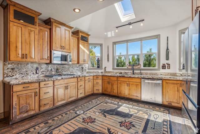 8938 N Canyon Wash Dr, Eagle Mountain, UT 84005 - kitchen featuring stainless steel appliances, a skylight, a wealth of natural light, and light stone countertops