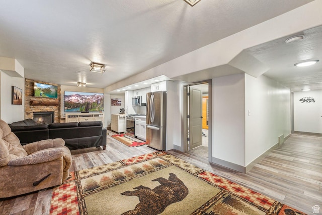 8938 N Canyon Wash Dr, Eagle Mountain, UT 84005 - living area featuring baseboards, a stone fireplace, and light wood finished floors