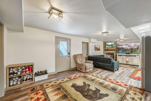 8938 N Canyon Wash Dr, Eagle Mountain, UT 84005 - living room featuring baseboards, wood finished floors, and a stone fireplace