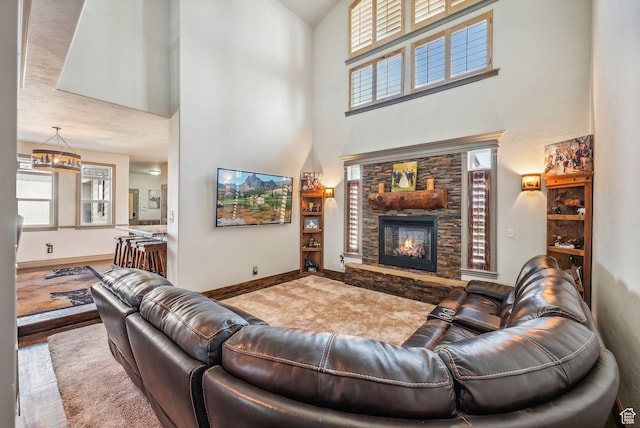 8938 N Canyon Wash Dr, Eagle Mountain, UT 84005 - living area featuring baseboards, plenty of natural light, a stone fireplace, and a high ceiling