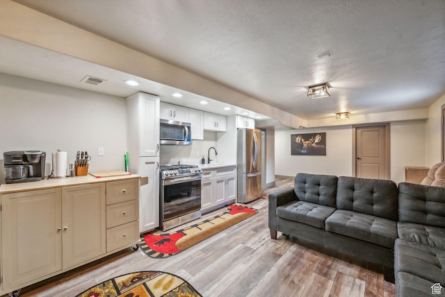 8938 N Canyon Wash Dr, Eagle Mountain, UT 84005 - living area with light wood-style floors, visible vents, a textured ceiling, and recessed lighting