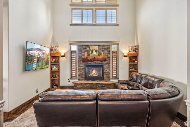 8938 N Canyon Wash Dr, Eagle Mountain, UT 84005 - living room featuring a high ceiling, baseboards, wood finished floors, and a stone fireplace