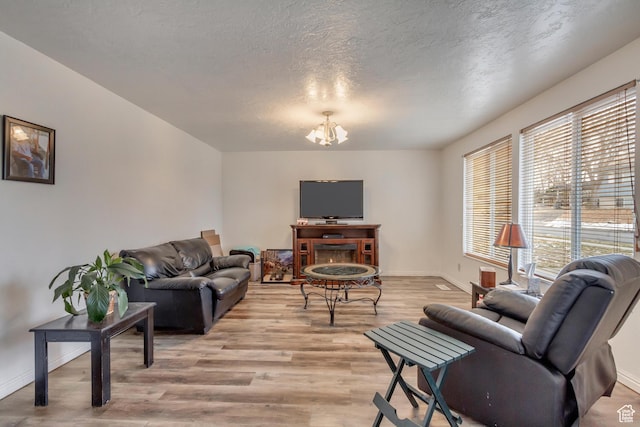 10551 Violet Dr, Sandy, UT 84094 - living room featuring a chandelier, light wood-type flooring, and a textured ceiling