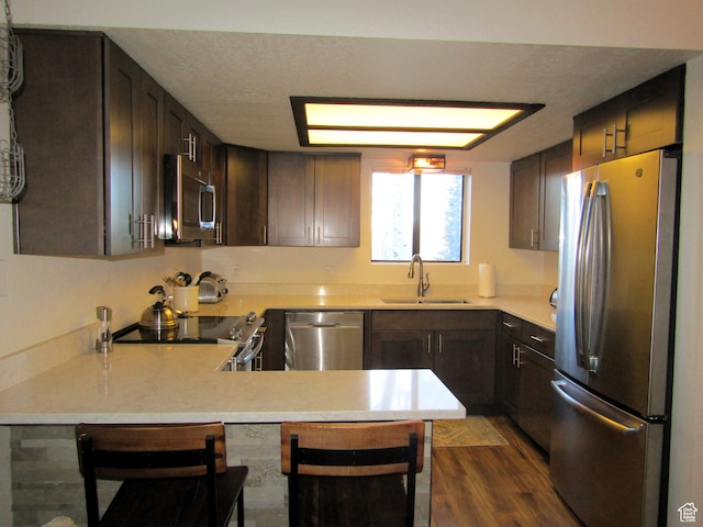 102 S Alpine Ln # A-4, Brian Head, UT 84719 - kitchen with sink, kitchen peninsula, dark wood-type flooring, stainless steel appliances, and a breakfast bar