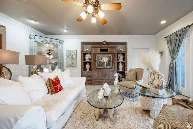 living room featuring crown molding and ceiling fan
