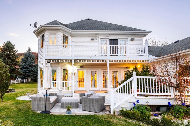 back of house with a lawn, outdoor lounge area, a balcony, and roof with shingles