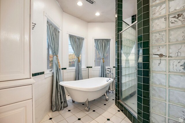 full bath with tile walls, a tile shower, tile patterned floors, a soaking tub, and recessed lighting