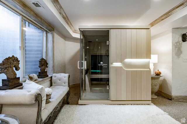 sitting room featuring carpet floors, baseboards, a textured wall, and visible vents
