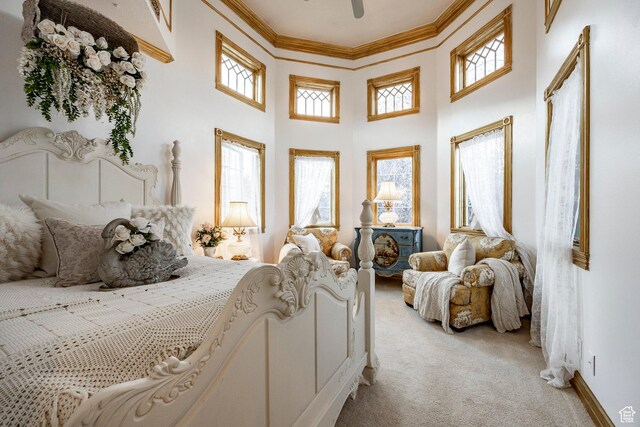 bedroom featuring ornamental molding, a towering ceiling, multiple windows, and light carpet