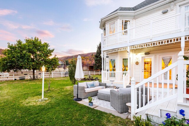 view of yard featuring fence, a patio area, outdoor lounge area, and a balcony
