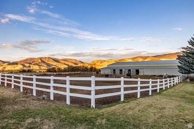 view of yard with fence, an outbuilding, and a mountain view