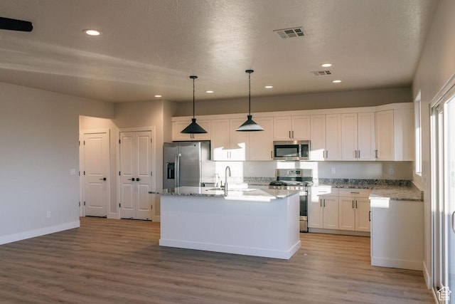 803 W 430 N, Hurricane, UT 84737 - kitchen with stainless steel appliances, white cabinetry, wood finished floors, recessed lighting, and a kitchen island with sink